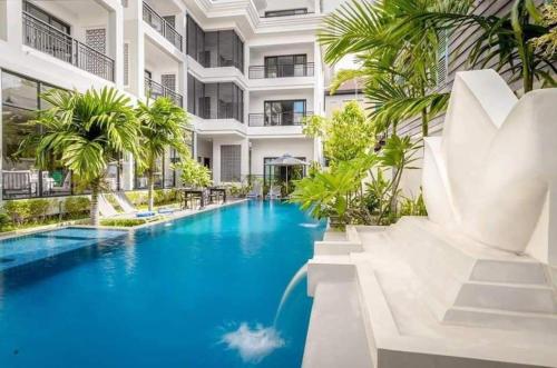 a pool in the middle of a building with palm trees at Angkor Style Resort & Spa in Phumi Ta Phul