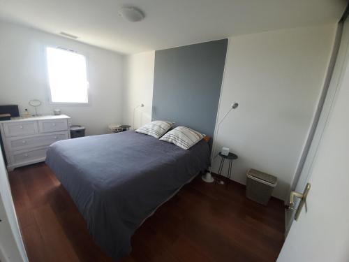 een slaapkamer met een bed, een dressoir en een raam bij La villa d'Evalou in Calvisson
