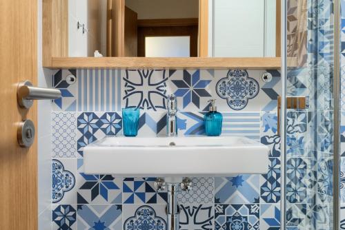カールスボリにある2. Apartmán na Faře mezonetの青と白のタイルを用いたバスルーム(シンク付)