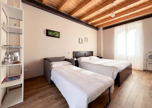 a room with three beds and a book shelf at RIAREL- Foresteria Lombarda in Rodero