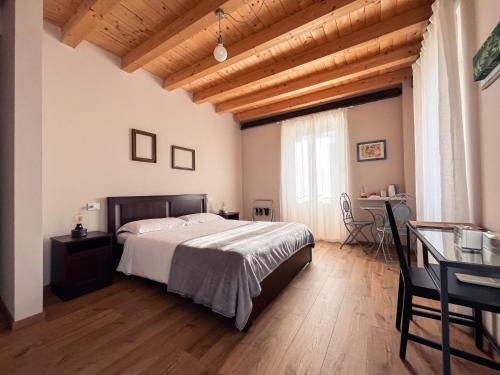 Schlafzimmer mit einem Bett, einem Tisch und einem Schreibtisch in der Unterkunft RIAREL- Foresteria Lombarda in Rodero