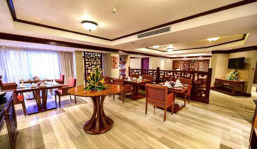 a restaurant with tables and chairs in a room at Kampala Serena Hotel in Kampala