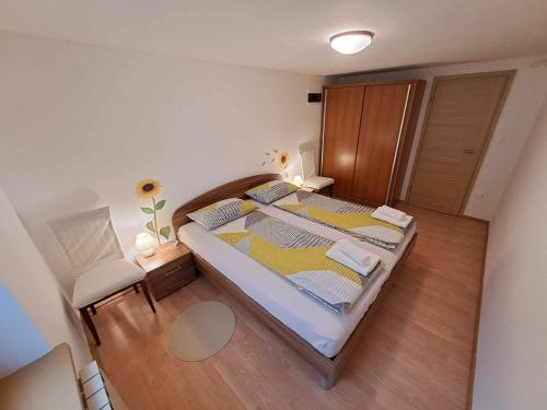 a small bedroom with a bed and a chair at Apartma Nando in Bovec