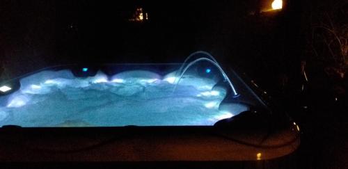 a swimming pool at night with lights in it at Resort EDEN - domki, pokoje, apartamenty, sauna, jacuzzi in Jastrzębia Góra