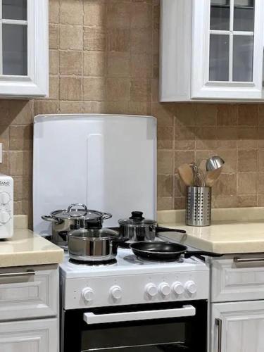 a kitchen with a stove with pots and pans on it at Luxurious Apartment Partial Sea View in Jeddah