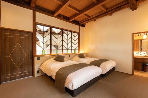 2 camas en un dormitorio con ventana en 十八楼離れ 宿いとう, en Gifu