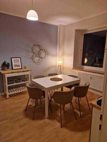 une salle à manger avec une table et des chaises blanches dans l'établissement Avali, à Bochum