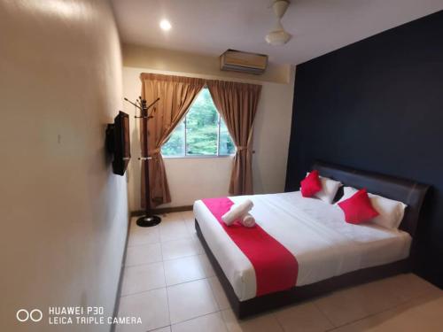 a bedroom with a bed with red and white pillows at FERRINGHI PARADISE HOTEL in Batu Ferringhi