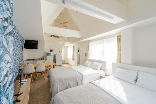 a hotel room with two beds and a kitchen at ILIMA Higashi Nakano in Tokyo