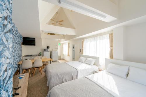 une chambre d'hôtel avec deux lits et une cuisine dans l'établissement ILIMA Higashi Nakano 新宿から電車で5分 東中野駅まで徒歩2分 最大4人 洗濯機 ダイニングキッチン 電子レンジ, à Tokyo