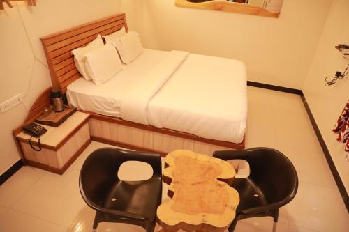 a small bedroom with a bed and a chair at The Woodlands Residency- Unmarried and stag groups not allowed in Ooty