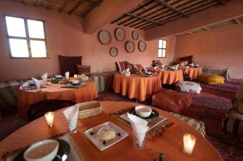MhamidにあるErg Chegaga Desert Standard Campの広い客室で、テーブル数台が備わります。