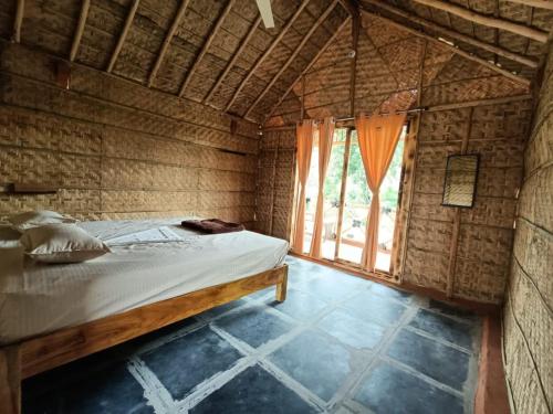 een slaapkamer met een bed in een kamer met een raam bij Rasta Cafe Hmpi in Hampi