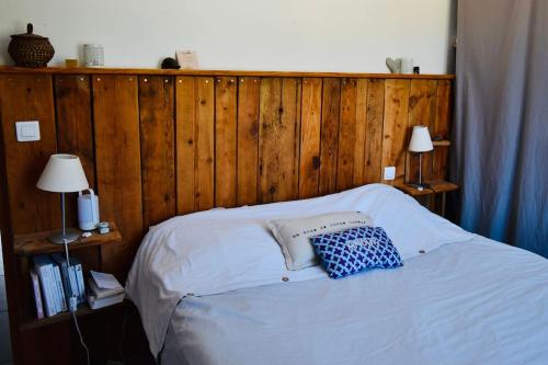 une chambre avec un lit avec une tête de lit en bois dans l'établissement Villa avec piscine, à Montpeyroux