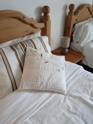 a bed with white sheets and pillows on it at Gite Les Volets Bleus du Segur in Le Ségur-Suech