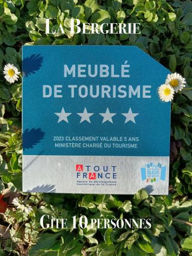 a blue sign with stars on a bush with flowers at Gite Les Volets Bleus du Segur in Le Ségur-Suech