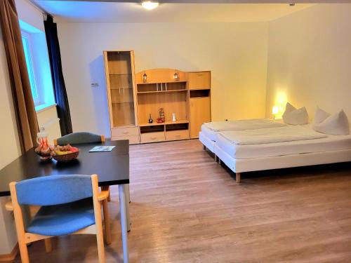 sypialnia z łóżkiem i stołem oraz jadalnia w obiekcie Ferienpark Thüringer Wald w mieście Schalkau