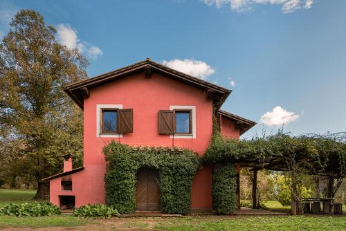 uma casa vermelha com hera ao lado em Casale Pomodoro em Manziana