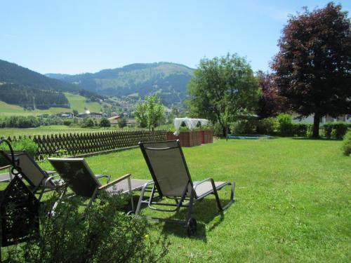 a group of chairs sitting in the grass at Haus Sonnwend in Ellmau