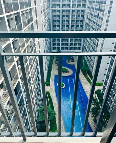 a view of a pool from a balcony with buildings at Shabby Chic & Contemporary Condo in Manila