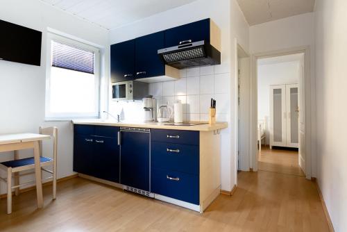 a kitchen with blue cabinets and a counter top at Feriendorf Slawitsch in Bad Sulza