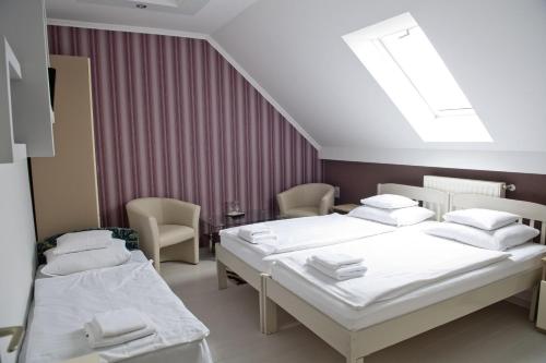 a hospital room with two beds and chairs at Kemence Csárda és Szálloda in Nyíregyháza