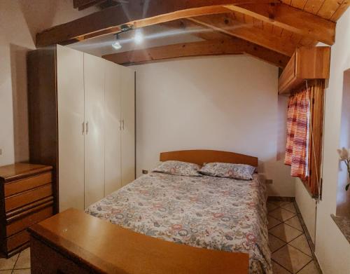 een kleine slaapkamer met een bed en een dressoir bij Mansarda de Legn in Cannobio