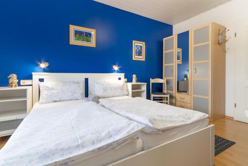 a bedroom with a large bed with a blue wall at Feriendorf Slawitsch in Bad Sulza