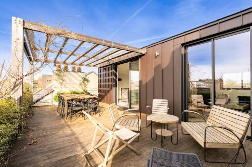 d'une terrasse avec des chaises, des tables et une table offrant une vue. dans l'établissement Le Studio Nantais - Loft moderne avec rooftop, à Nantes