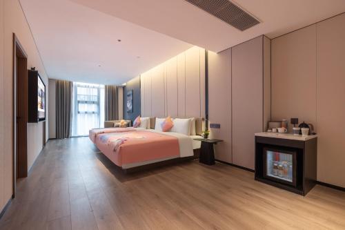 a bedroom with a large bed and a fireplace at Atour Hotel Guangzhou Panyu Wanbo CBD Hanxi Changlong in Guangzhou