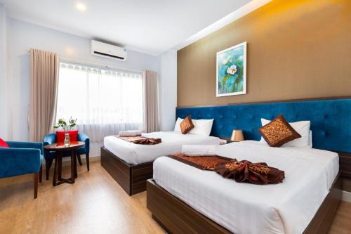 a hotel room with two beds and a window at Khách sạn Bamboo Sài gòn in Ho Chi Minh City