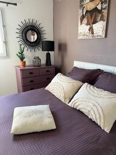 une chambre avec un lit violet et un miroir dans l'établissement La Maison de la Côte 4 pers. Prest'immo, à Fleury