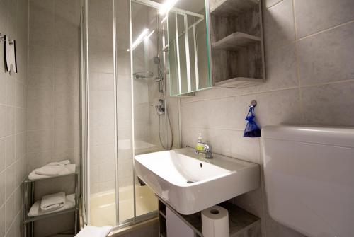 a white bathroom with a sink and a shower at Feriendorf Slawitsch in Bad Sulza