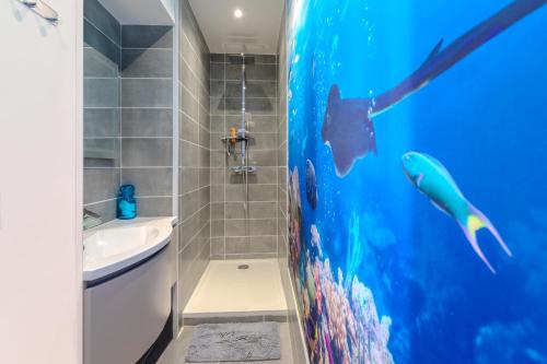 a bathroom with a fish mural on the wall at Appartement esprit Tahitien in Rivesaltes