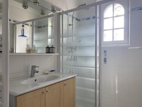 une salle de bain blanche avec un lavabo et une douche dans l'établissement 755 -Maison en pierre à Erquy proche de la plage, à Erquy