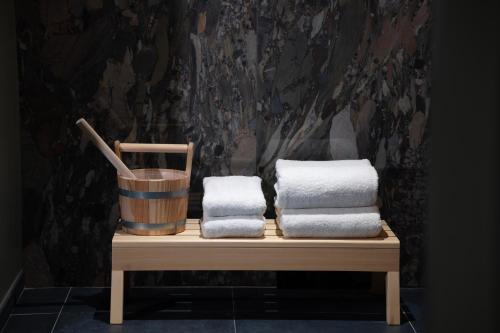 a pile of towels sitting on a table with a bucket at Hotel des Carmes by Malone in Paris