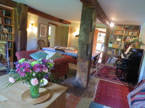a living room with a vase of flowers on a table at Sockbridge Mill Bed and Breakfast in Penrith