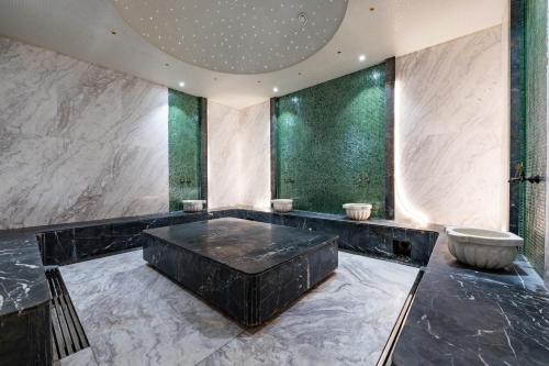 a bathroom with a tub and a toilet in it at Wyndham Garden Burabay in Borovoye