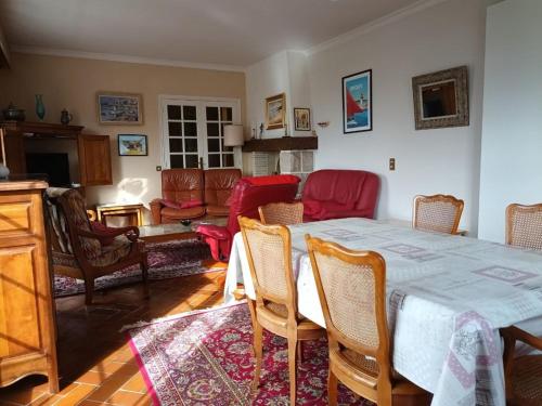 un salon avec une table, des chaises et un canapé dans l'établissement 800 - Maison de charme proche du centre d'Erquy, à Erquy