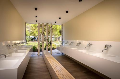 a row of sinks in a public restroom at Maistra Camping Koversada Uncovered Naturist Pitches in Vrsar