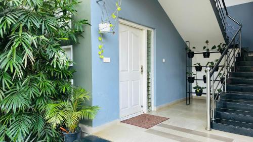 a hallway with a blue wall and a white door at Western Ghats Holiday Home in Kalpetta