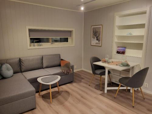 特羅姆瑟的住宿－Elvenes, krypinn for to，客厅配有沙发和桌子