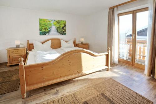 Un dormitorio con una gran cama de madera y una ventana en Gästehaus Bergfrieden, en Bolsterlang