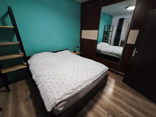 małą sypialnię z łóżkiem i lustrem w obiekcie Mieszkanie Tarnowo Podgórne w mieście Tarnowo Podgórne