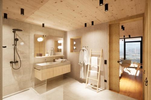 a bathroom with a sink and a shower and a mirror at PANORAMA Allgäu Spa Resort in Seeg