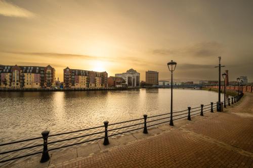 a body of water with buildings and a street light at Beautiful City Center Apartment with a River View - Free Parking! in Belfast