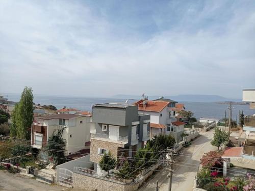 a view of a city with houses and the ocean at Seferihisar Akarca Denize 130 metre uzaklıkta in Seferihisar