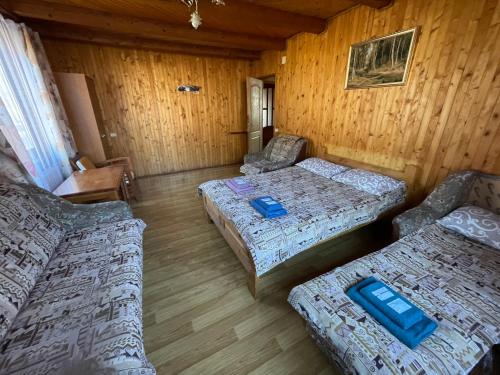 a room with two beds and two couches in it at Kryvorizka Palanka in Mykulychyn