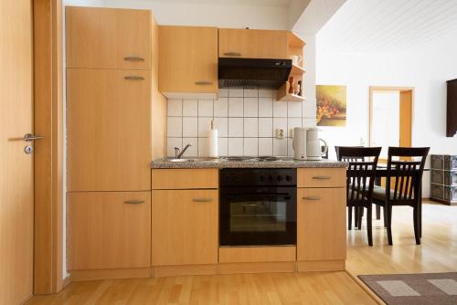 a kitchen with wooden cabinets and a stove at Feriendorf Slawitsch in Bad Sulza