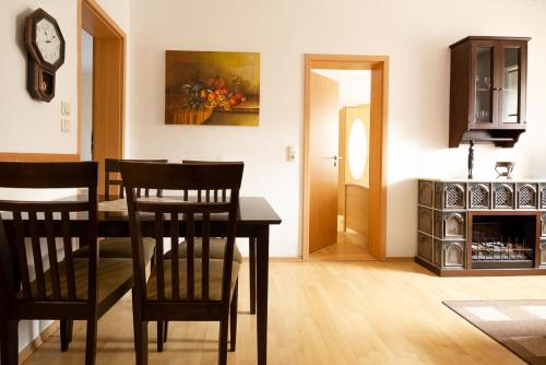 a living room with a table and chairs and a clock at Feriendorf Slawitsch in Bad Sulza